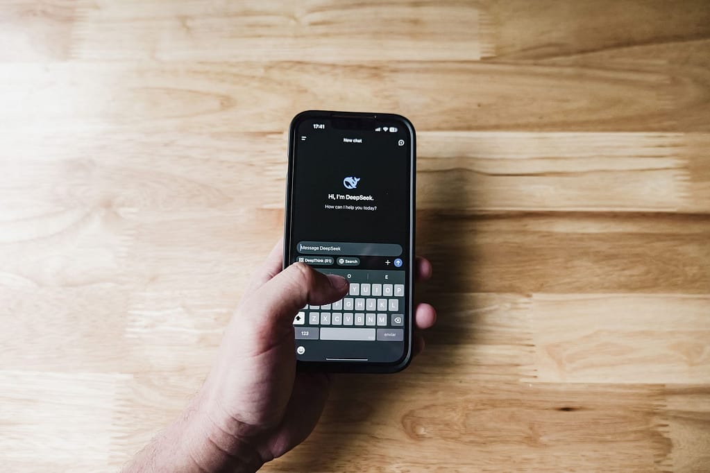 Tangan memegang smartphone yang menampilkan antarmuka chatbot AI DeepSeek, salah satu produk AI yang bisa diakses di Indonesia