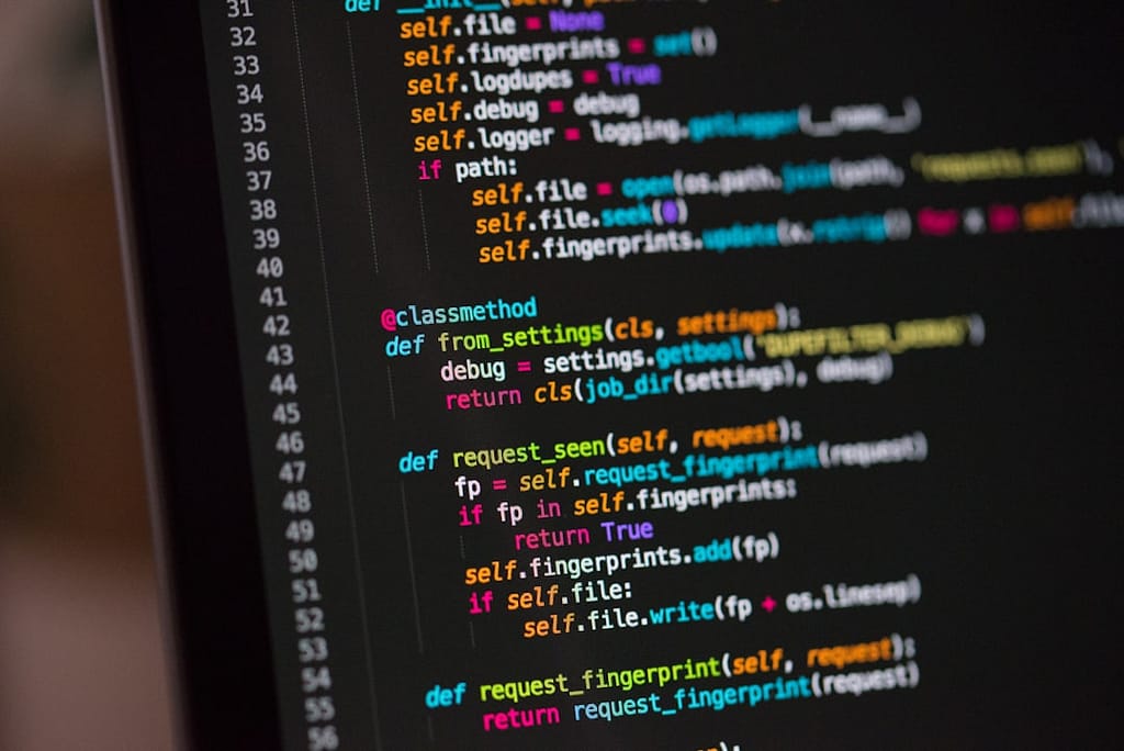 Kode Python ditampilkan di layar monitor gelap — contoh project pertama untuk pemula
